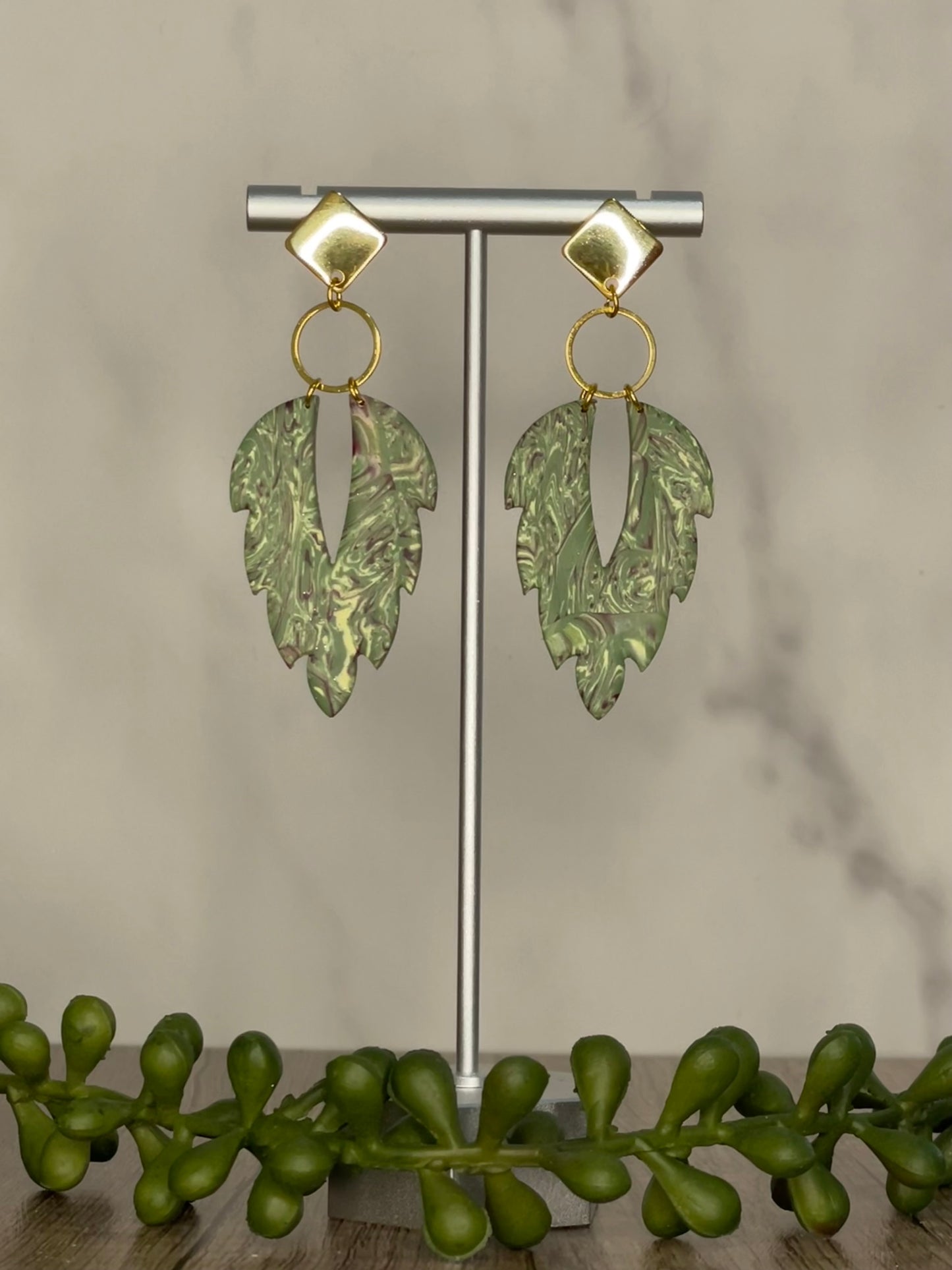 Gold and green swirled leaf dangle earrings